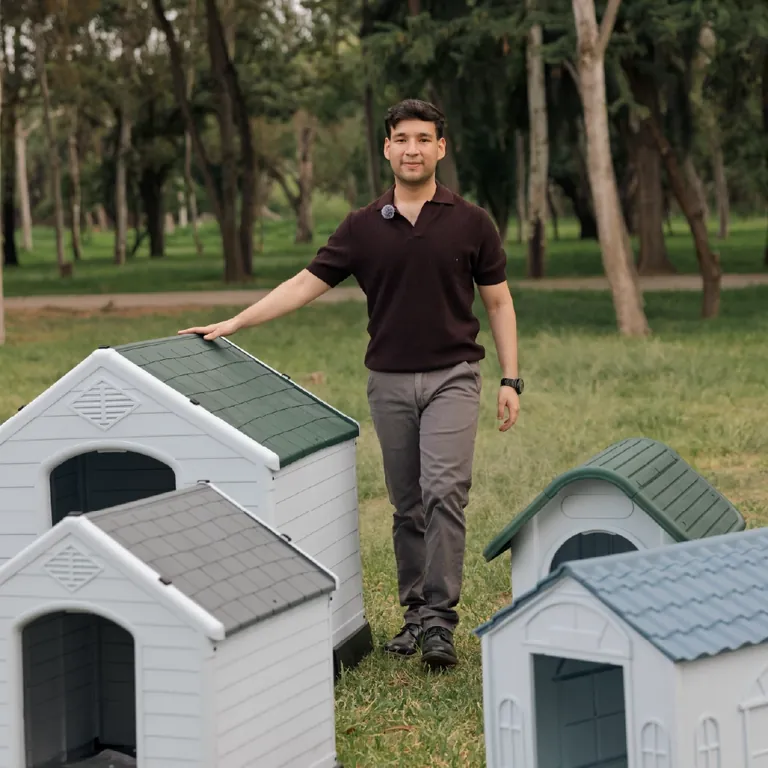 Persona junto a casas para mascota DIDAÏK en jardín exterior